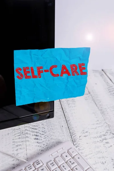 Handwriting text Self Care. Concept meaning the practice of taking action to improve one s is own health Notation paper taped to black computer monitor screen near white keyboard. — Stock Photo, Image