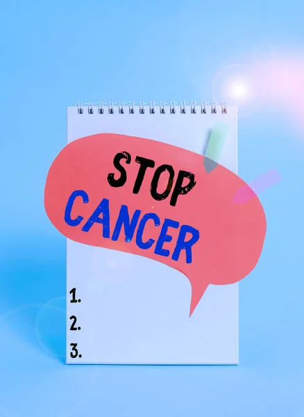 Text sign showing Stop Cancer. Conceptual photo prevent the uncontrolled growth of abnormal cells in the body Spiral notepad speech bubble arrow banners lying cool pastel background.