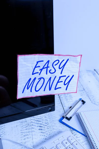 Text sign showing Easy Money. Conceptual photo money that is easily have and sometimes dishonestly earned Note paper taped to black computer screen near keyboard and stationary.