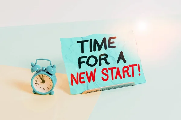 Writing note showing Time For A New Start. Business photo showcasing Trust the magic of Beginnings Afresh Anew Rebirth Alarm clock beside a Paper sheet placed on pastel backdrop. — Stok fotoğraf