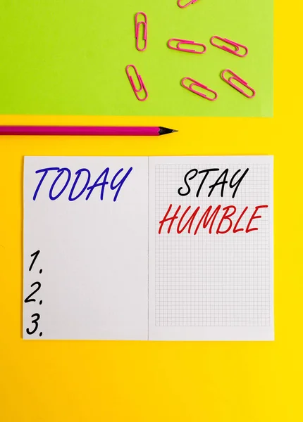 Handwriting text writing Stay Humble. Concept meaning not proud or arrogant Modest to be humble although successful Blank squared notebook pencil marker paper sheet plain colored background. — 图库照片