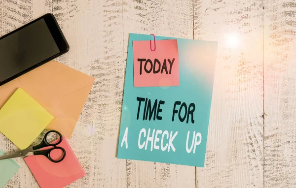 Writing note showing Time For A Check Up. Business photo showcasing a Thorough Examination have a Look on something someone Envelope paper sheet smartphone notepads scissors wooden background.