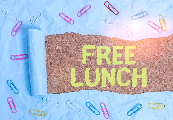 Text sign showing Free Lunch. Conceptual photo something you get free that you usually have to work or pay for Paper clip and torn cardboard placed above a wooden classic table backdrop.