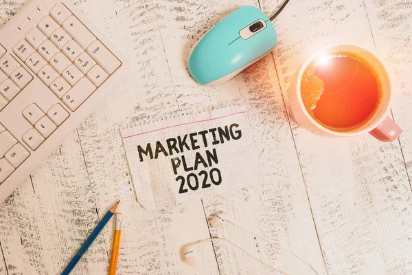 Escritura a mano conceptual que muestra Plan de Marketing 2020. Horario de presentación de fotos de negocios que define el camino de venta de la marca en el próximo año. Dispositivos tecnológicos, recordatorios de color, materiales de oficina de papel. . — Foto de Stock