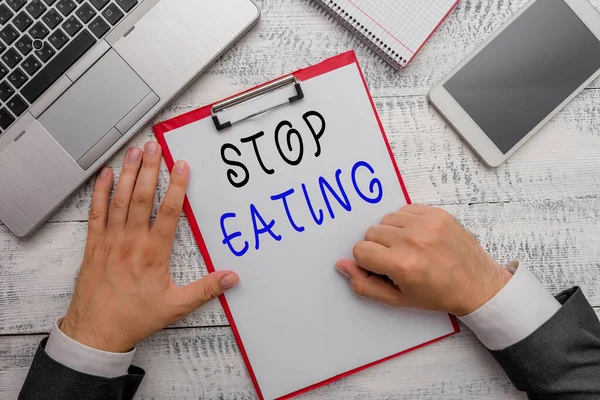 文章を書く食べるのをやめなさい。口の中に食品を入れたり取ったりする活動を中止するためのビジネスコンセプト現代のハイテクノートパソコンデバイスの近くに手書きの機器ツールを保持. — ストック写真