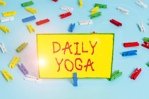 Word writing text Daily Yoga. Business concept for series of Yoga workouts to train different parts of your body Colored clothespin papers empty reminder blue floor background office pin.