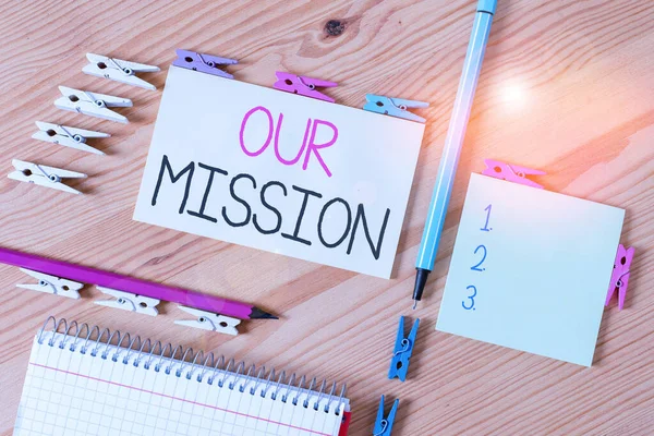 Writing note showing Our Mission. Business photo showcasing A written declaration of an organization s is core purpose Colored clothespin papers empty reminder wooden floor background office.