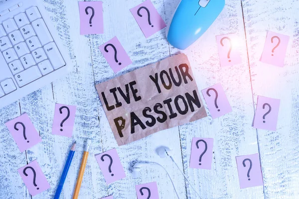 Text sign showing Live Your Passion. Conceptual photo Doing something you love that you do not consider a job Writing tools, computer stuff and scribbled paper on top of wooden table.