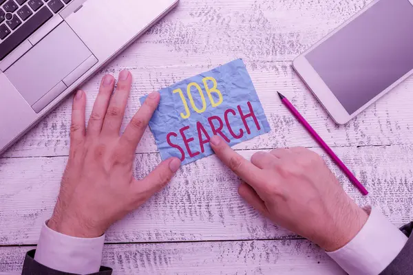 Conceptual hand writing showing Job Search. Business photo text An act of demonstrating to find work suited for his profession Hand hold note paper near writing equipment and smartphone.