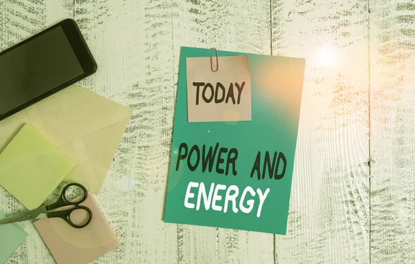 Escrevendo uma nota mostrando Energia e Energia. Foto de negócios mostrando Eletricidade indústria de distribuição elétrica Envelope energético folha de papel Smartphone notepads tesoura fundo de madeira . — Fotografia de Stock