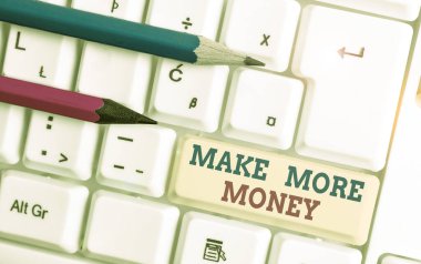 Daha fazla para kazandığımı gösteren bir not yazıyorum. İş fotoğrafı gösterimi Gelir gelirlerinizi artırın Beyaz PC klavye ile daha çok çalışın beyaz arkaplan üzerinde not kağıdı ile.