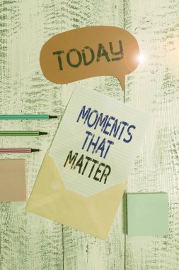 Writing note showing Moments That Matter. Business photo showcasing Meaningful positive happy memorable important times Envelop speech bubble paper sheet ballpoints notepads wooden background. clipart