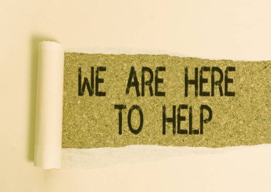 Conceptual hand writing showing We Are Here To Help. Business photo showcasing Someone who is always ready to Assist Support Give Cardboard which is torn placed above a wooden classic table.