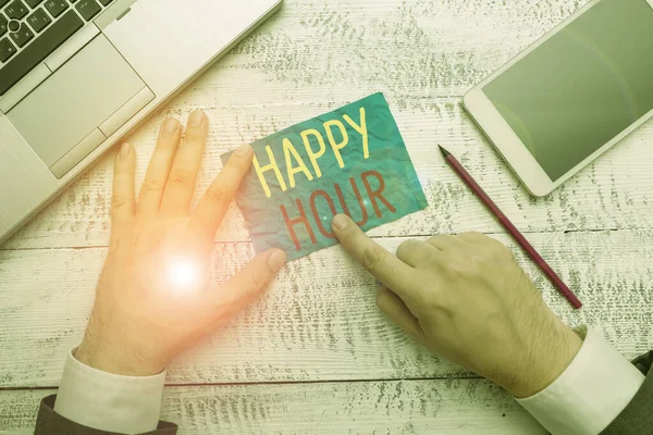 Conceptual hand writing showing Happy Hour. Business photo text when drinks are sold at reduced prices in a bar or restaurant Hand hold note paper near writing equipment and smartphone. — Stock Photo, Image