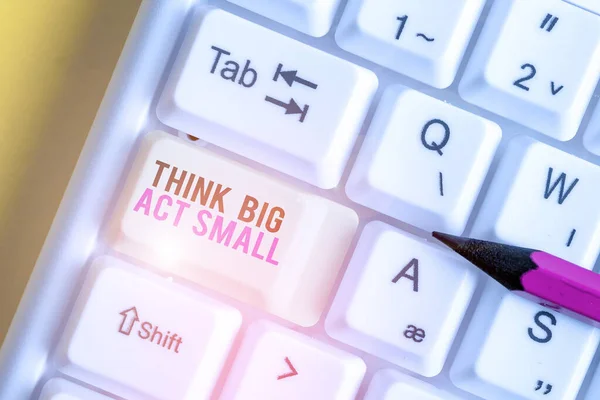 Texto escrito à mão Think Big Act Small. Conceito que significa grandes metas ambiciosas Dê pequenos passos um de cada vez Teclado de PC branco com papel de nota vazio acima do espaço de cópia de chave de fundo branco . — Fotografia de Stock