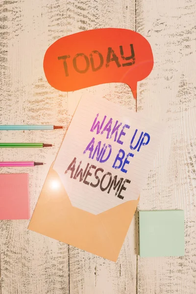 Note d'écriture montrant Wake Up And Be Awesome. Photo d'affaires montrant Rise up and Shine Démarrer la journée Droit et lumineux Envelopper la parole bulle feuille de papier billes blocs-notes fond en bois . — Photo