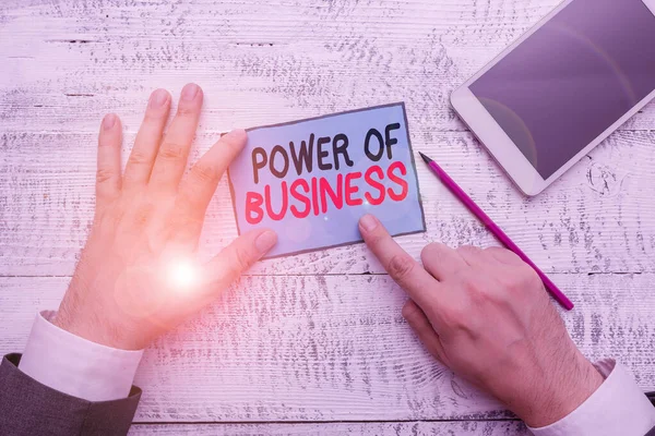 Writing note showing Power Of Business. Business photo showcasing The ability to influence peers for attaining the goals Hand hold note paper near writing equipment and smartphone.