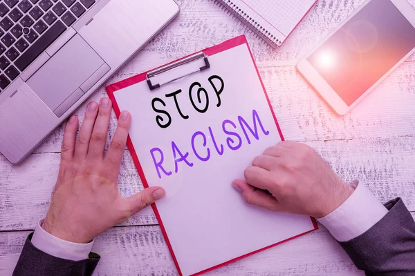 Woord schrijven tekst Stop Racisme. Zakelijk concept voor het einde van de antagonisme gericht tegen iemand van een ander ras Handhold schrijfapparatuur gereedschap in de buurt van moderne high-tech laptop apparaat. — Stockfoto