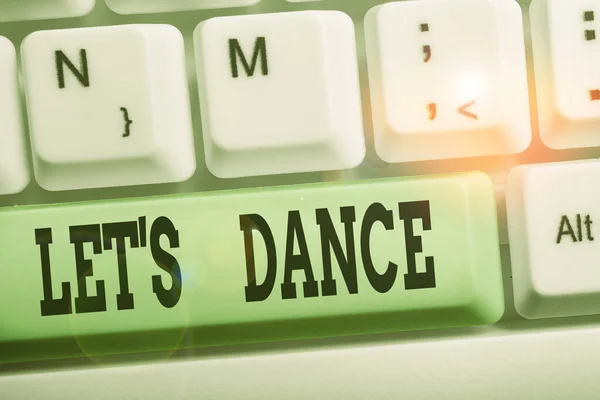 Handwriting text writing Let S Is Dance. Concept meaning move rhythmically to music following a set sequence of steps White pc keyboard with empty note paper above white background key copy space.