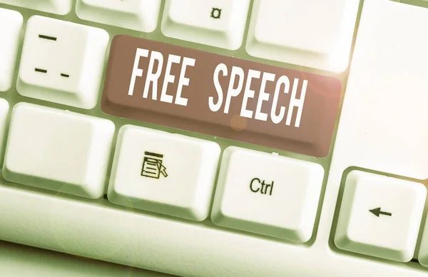 Writing note showing Free Speech. Business photo showcasing the right of showing to express their opinions publicly White pc keyboard with note paper above the white background.