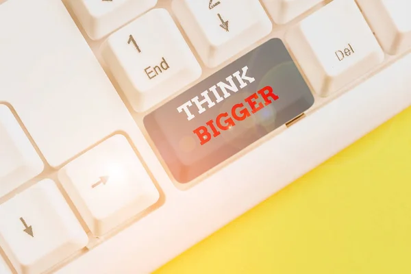 Texto de escritura de palabras Think Bigger. Concepto de negocio para poder soñar y visualizar lo que puede lograr Teclado blanco para PC con papel de nota vacío sobre el espacio de copia de la tecla de fondo blanco . — Foto de Stock