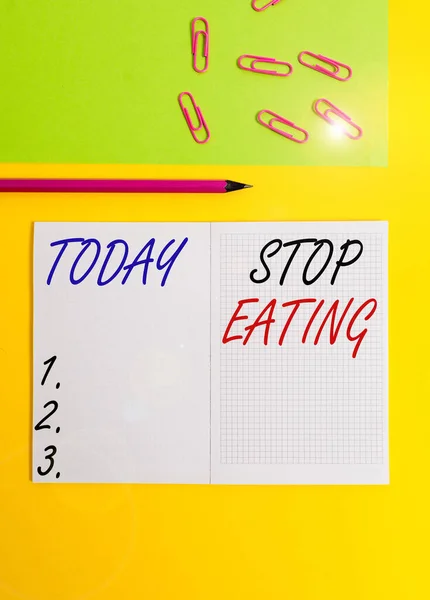 Handwriting text writing Stop Eating. Concept meaning cease the activity of putting or taking food into the mouth Blank squared notebook pencil marker paper sheet plain colored background. — Stockfoto