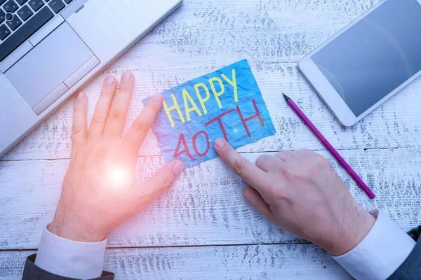 Conceptual hand writing showing Happy 40Th. Business photo text a joyful occasion for special event to mark the 40th year Hand hold note paper near writing equipment and smartphone.