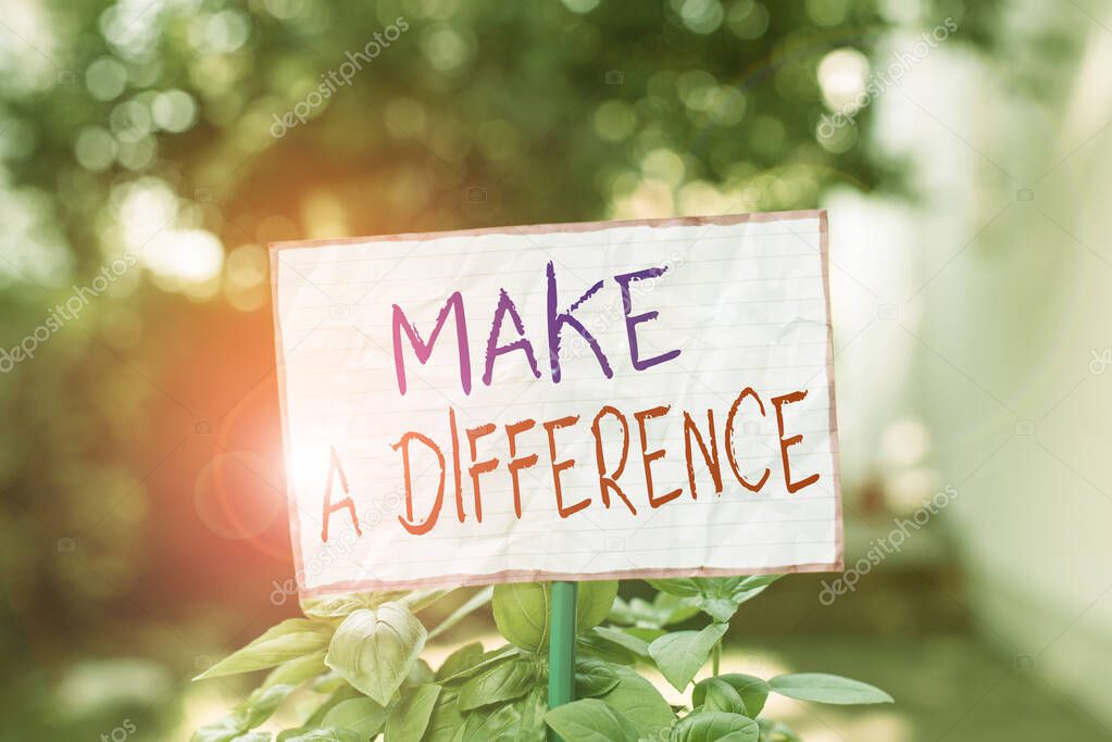 Conceptual hand writing showing Make A Difference. Business photo showcasing Mark an effect on a demonstrating or situation Cause a change Plain paper attached to stick and placed in the grassy land.