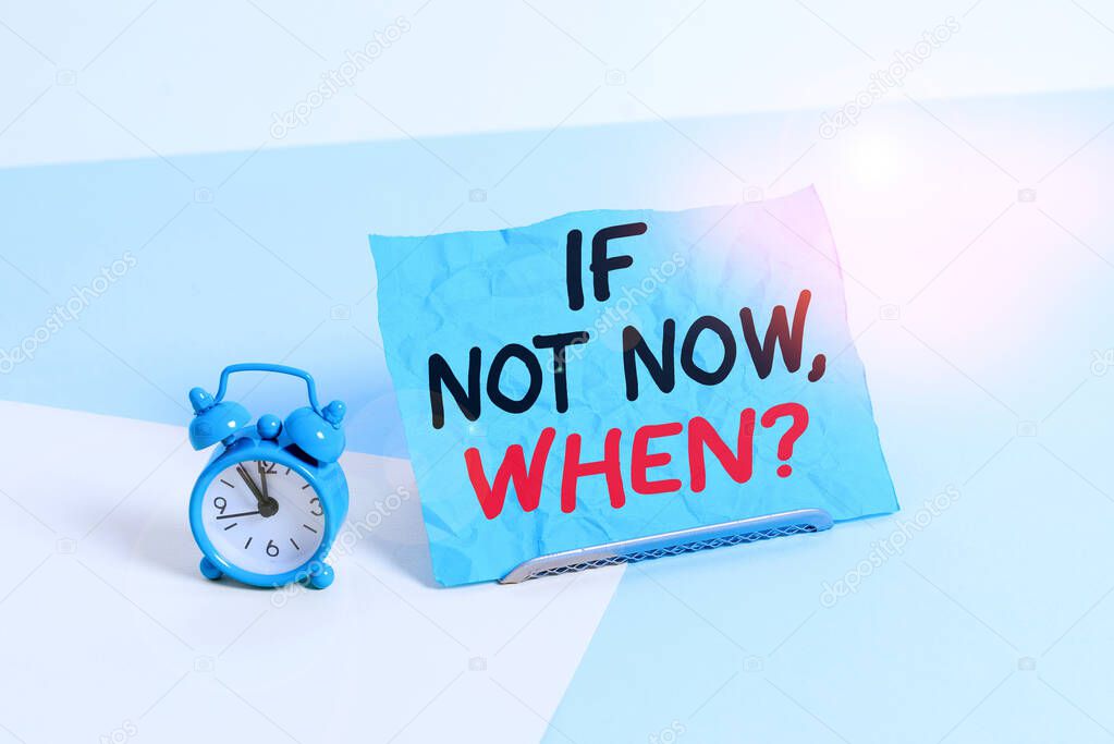 Writing note showing If Not Now When Question. Business photo showcasing start acting from this moment do not hesitate Alarm clock beside a Paper sheet placed on pastel backdrop.