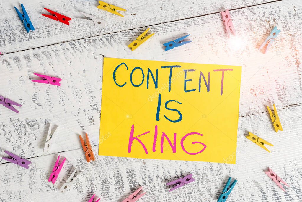 Conceptual hand writing showing Content Is King. Business photo text Content is the heart of todays marketing strategies Colored clothespin rectangle shaped paper blue background.