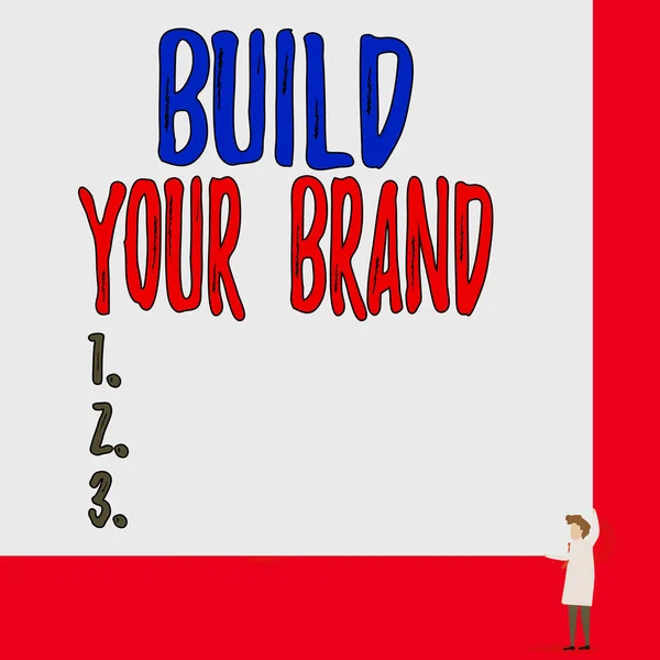 Text sign showing Build Your Brand. Conceptual photo enhancing brand equity using advertising campaigns One man professor wear white coat red tie hold big board use two hands.