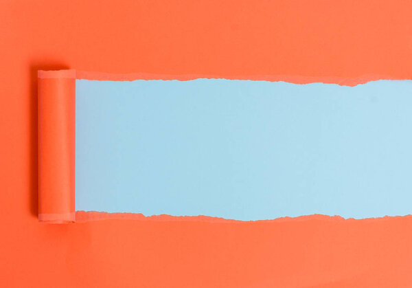 Картон разрывается посередине, расположенной над мягким цветным столом. Толстая рваная бумага на пастельном фоне. Художественный способ упорядочивания плоской кладет фотографию
