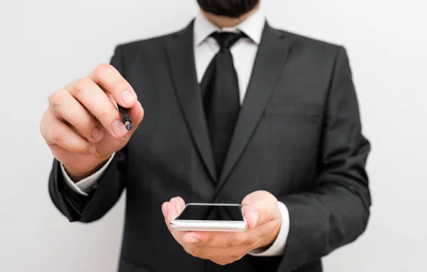 Hombre humano con barba usar ropa de trabajo formal celebrar dispositivo de teléfono inteligente de alta tecnología. Hombre vestido con traje de trabajo más corbata sosteniendo un pequeño teléfono móvil de alta tecnología con una mano — Foto de Stock