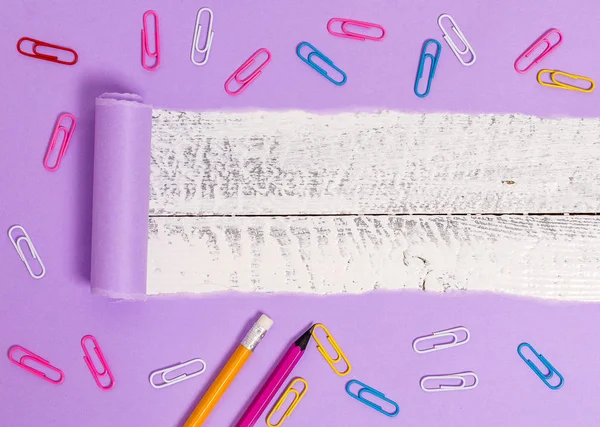 Cartón rasgado con clip de papel colocado encima de una mesa clásica de madera. Papel grueso desgarrado y fijo sobre un fondo de madera texturizada. Manera artística de organizar planos pone fotografía — Foto de Stock