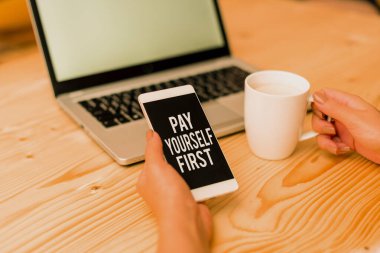 Writing note showing Pay Yourself First. Business photo showcasing Saving for future Setting aside a Portion of your income woman with laptop smartphone and office supplies technology.