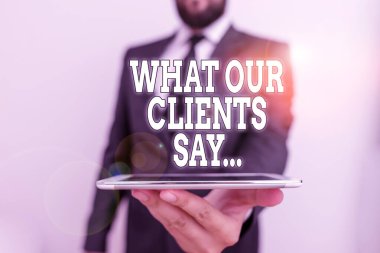 Word writing text What Our Clients Say. Business concept for your customer feedback using poll or written paper Male human wear formal work suit hold smart hi tech smartphone use one hand.