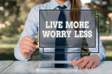 Daha Az Endişeli Yaşa tabelasını gösteriyor. Kavramsal fotoğraf iyi bir tutum motivasyonu var dikkatsiz ol hayatın tadını çıkar masa başında oturan ve cep telefonu tutan kadın iş adamı.