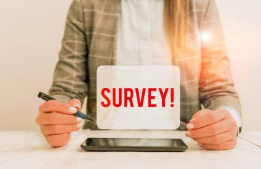 Anketi gösteren mesaj işareti. Önceden tanımlanmış bir gruptan veri toplamak için kullanılan kavramsal fotoğraf araştırma yöntemi. Elinde cep telefonu ve kalemle oturan iş kadını..