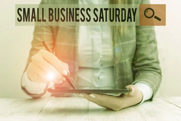 Escrevendo uma nota mostrando Small Business Saturday. Foto de negócios mostrando feriado americano de compras realizadas durante o sábado Mulher de negócios sentado com telefone celular e caneta na mão . — Fotografia de Stock
