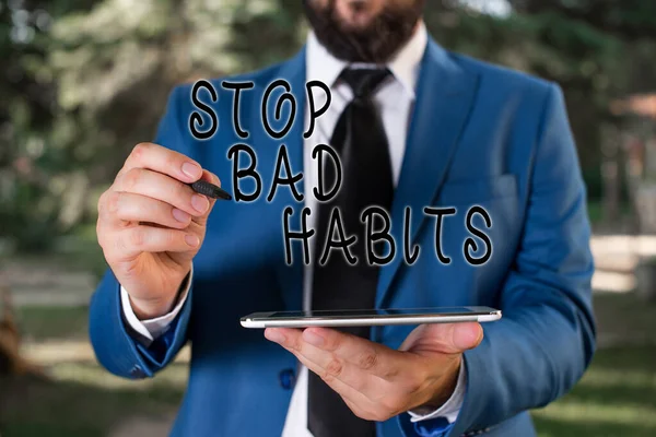 Writing note showing Stop Bad Habits. Business photo showcasing asking someone to quit doing non good actions and altitude Businessman in blue suite stands with mobile phone in hands.