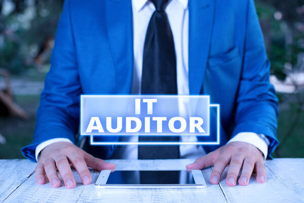 Writing note showing It Auditor. Business photo showcasing demonstrating authorized to review and verify the accuracy of the system Businessman in blue suite with a tie holds lap top in hands.