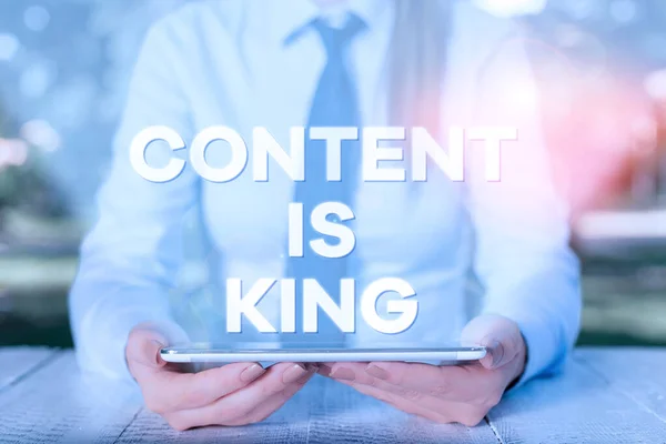 Tulisan tangan dalam Content Is King. Konsep makna Isi adalah jantung dari hari ini strategi pemasaran Perempuan pengusaha duduk dengan meja dan memegang ponsel . — Stok Foto