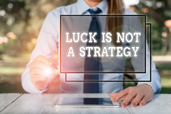 Text sign showing Luck Is Not A Strategy. Conceptual photo it is not being Lucky when planned intentionally Female business person sitting by table and holding mobile phone.