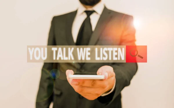 Texto de escritura de palabras You Talk We Listen. Concepto de negocio para la comunicación bidireccional Conversación motivacional El traje de trabajo formal de desgaste humano masculino sostiene el smartphone inteligente de alta tecnología con una mano . —  Fotos de Stock