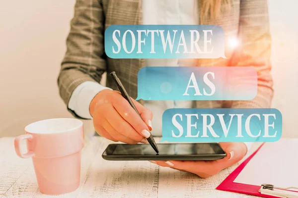 Writing note showing Software As Service. Business photo showcasing On Deanalysisd licensed on Subscription and centrally hosted Business concept with mobile phone in the hand. — Stockfoto
