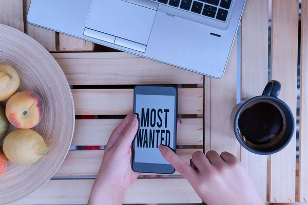 Handwriting text writing Most Wanted. Concept meaning listing of the names of demonstratings who are urgently being sought woman computer smartphone drink mug office supplies technological devices. — Stockfoto