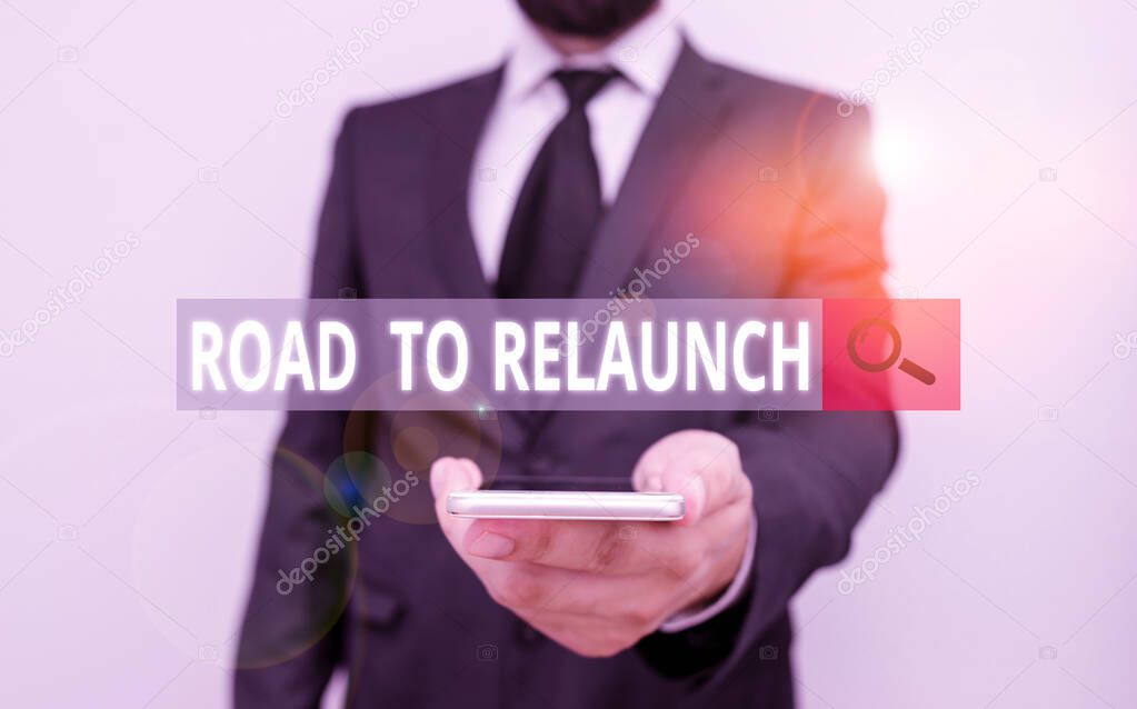 Word writing text Road To Relaunch. Business concept for In the way to launch again Fresh new start Beginning Male human wear formal work suit hold smart hi tech smartphone use one hand.