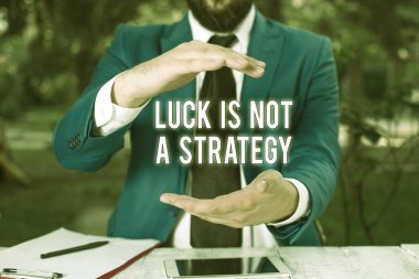 Şansın bir strateji olmadığını gösteren kavramsal el yazısı. İş fotoğraflarının sergilenmesi, kasıtlı olarak masanın önünde planlandığında Lucky olmak değildir. Cep telefonu ve notlar masanın üzerinde..