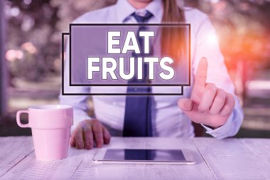 Ye Meyveleri 'ni gösteren bir mesaj. Kavramsal fotoğraf, huanalysiss ya da hayvanlar için yararlı olan bitki yetiştirme ürünlerini tüketir. Masanın başında oturan ve cep telefonu tutan kadın işadamı..