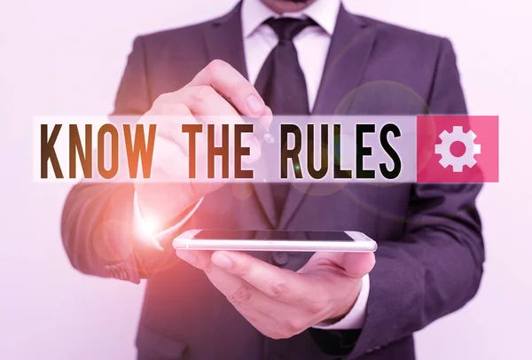 Text sign showing Know The Rules. Conceptual photo Learn the accepted principle or instructions to follow Male human wear formal work suit hold smart hi tech smartphone use one hand. — Stock Photo, Image